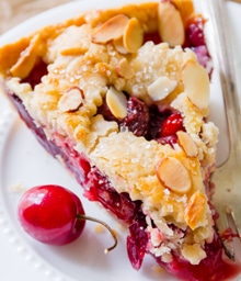 Piece of Sweet Cherry Pie topped with nuts.
