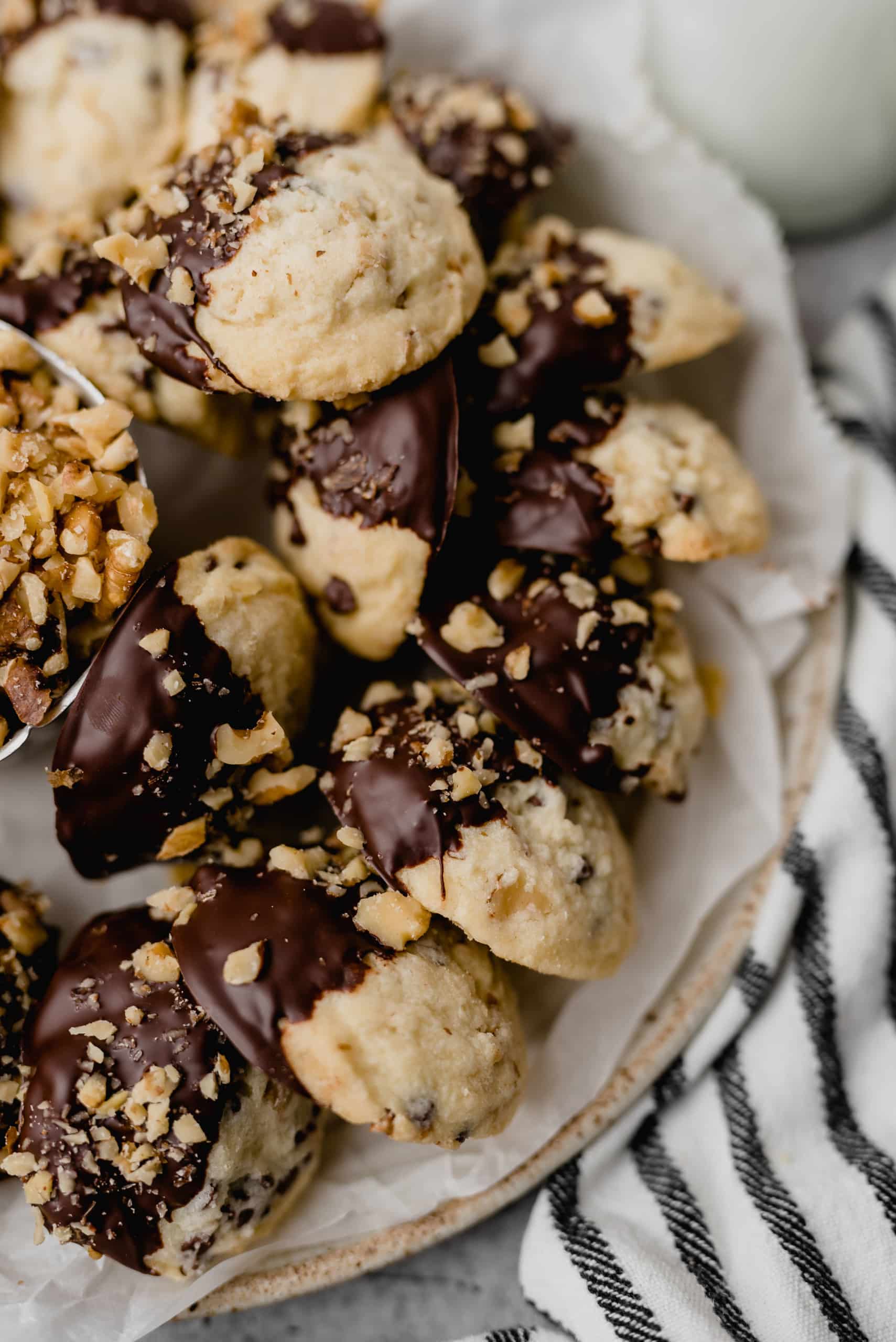 Plate of Walnut Butter Cookies dipped in chocolate and nuts.